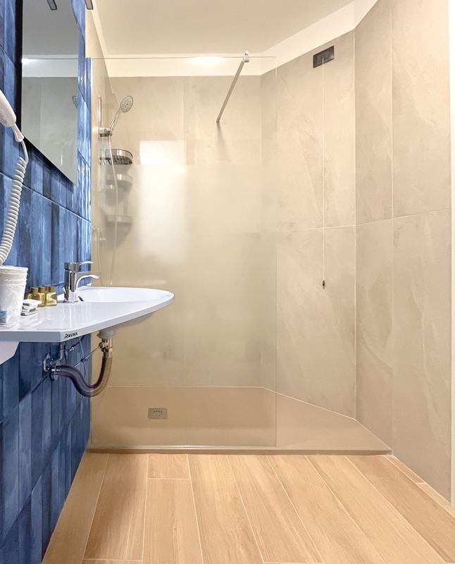 Lavabo e doccia del bagno con piastrelle blu