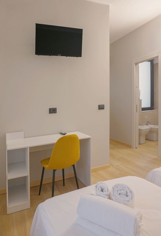 Scrivania, TV e porta del bagno nella camera quadrupla